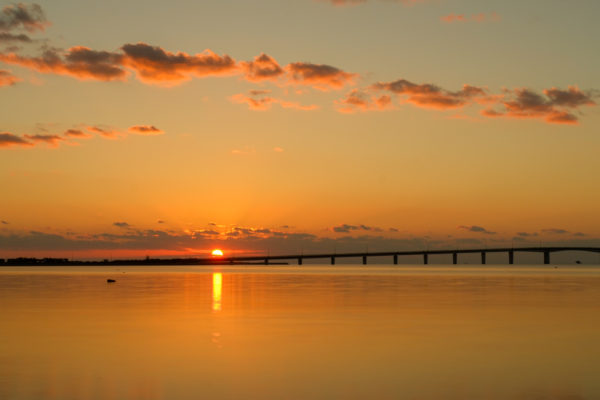うるま市ガイドマップ「うるまいろ」 浜比嘉大橋に昇る朝日（浜比嘉大橋）の画像